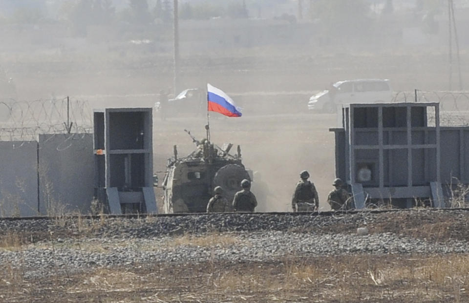 In this photo taken from the outskirts of Suruc, southeastern Turkey, AaRussian army vehicle enters Syria, as it begins its joint patrol with Turkish forces, Tuesday, Nov. 5, 2019. Turkey and Russia launched joint patrols for the second time in northeastern Syria, under a deal that halted a Turkish offensive against Syrian Kurdish fighters who were forced to withdraw from the border area following Ankara's incursion. (AP Photo/Mehmet Guzel)