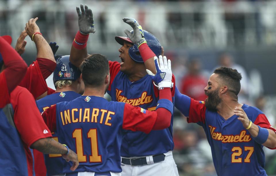 Venezuela's Salvador Perez, center, celebrates with teammates after a home-run in the 9th inning during a World Baseball Classic game against Italy, in Guadalajara, Mexico, Saturday, March 11, 2017. All-Star catcher Perez injured his left knee in a home-plate collision with his Kansas City Royals backup Drew Butera in a World Baseball Classic game. Venezuela rallied to beat Italy 11-10 on Martin Prado's 10th-inning double after Butera stumbled into Perez to end the ninth with the score tied at 10.(AP Photo/Luis Gutierrez)