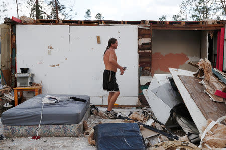 Gabriel Schaw, 40, walks through the remains of his home destroyed by Hurricane Michael in Fountain, Florida, U.S., October 15, 2018. REUTERS/Terray Sylvester