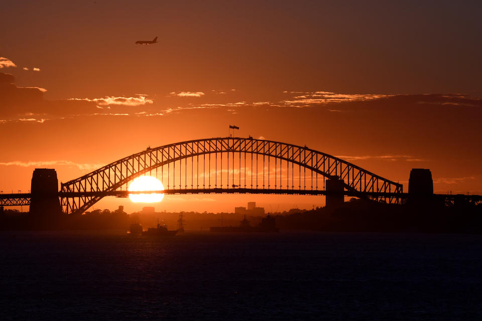 The sun can be seen setting behind the Sydney Harbour Bridge, in Sydney. Source: Getty Images