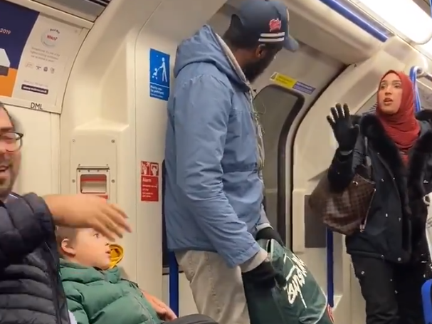 A woman in a headscarf argues with the man who racially abused the Jewish father and children (left): Chris Atkins / Twitter