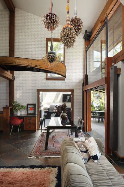 A fiber art installation by Joel S. Allen hangs from the living room ceiling, not far from the kitchen’s overhead canoe.