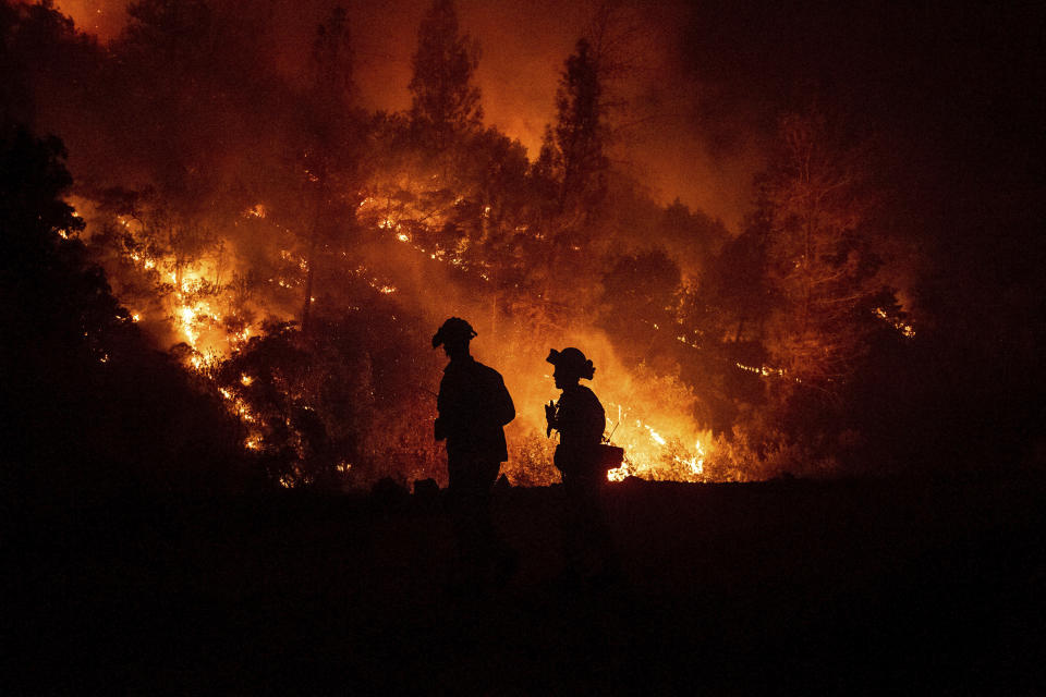 FILE - In this Aug. 7, 2018, file photo, firefighters monitor a backfire while battling the Ranch Fire, part of the Mendocino Complex Fire, near Ladoga, Calif. While California officials quickly determined an arsonist started the wildfire burning southeast of Los Angeles and that sparks from a vehicle produced the deadly wildfire in the city of Redding, causes for many of the state's worst blazes in the past decade remain a mystery. (AP Photo/Noah Berger, File)