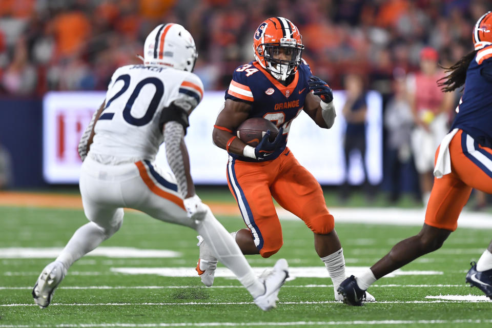 Syracuse running back Sean Tucker (34) runs with the ball while pressured by Virginia safety Jonas Sanker (20) during the first half of an NCAA college football game Friday, Sept. 23, 2022, in Syracuse, N.Y. (AP Photo/Adrian Kraus)