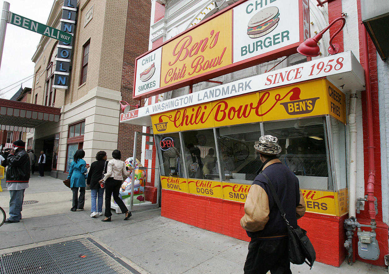 People walking on sidewalk in front of iconic Ben's Chili Bowl in Washington, DC