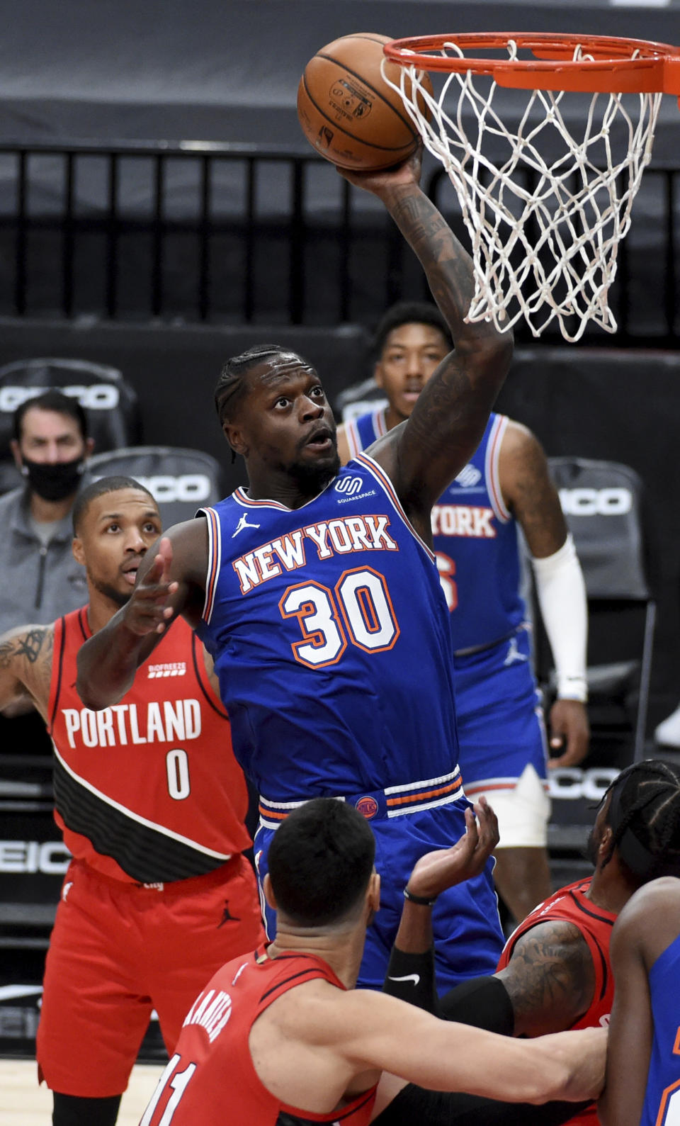 New York Knicks forward Julius Randle (30) drives to the basket on Portland Trail Blazers guard Damian Lillard, left, during the first quarter of an NBA basketball game in Portland, Ore., Sunday, Jan. 24, 2021. (AP Photo/Steve Dykes)