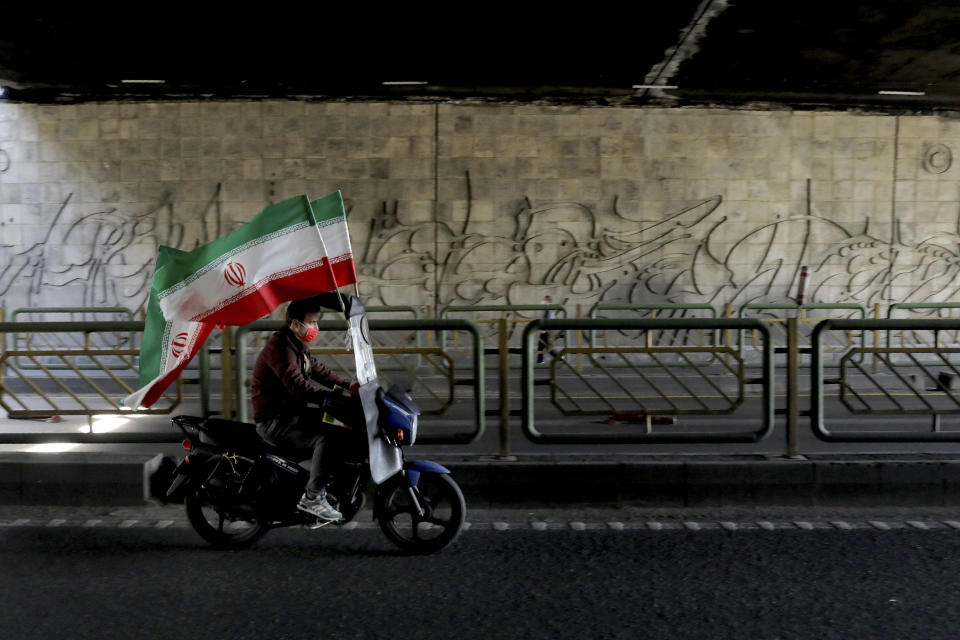 An Iranian man attends a rally marking the 42nd anniversary of the 1979 Islamic Revolution, in Tehran, Iran, Wednesday, Feb. 10, 2021. Tens of thousands are expected to drive through cities and towns on Wednesday as part of the manifestations after the government decided to replace traditional demonstrations with motorcades as a measure to prevent the spread of the coronavirus. (AP Photo/Ebrahim Noroozi)