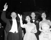 President Dwight Eisenhower and Mrs. Mamie Eisenhower wave to cheering crowd attending inaugural ball at the Statler Hotel in Washington on Jan. 21, 1957. With them is their son Maj. John Eisenhower, Mrs. Barbara Eisenhower. Ike and Mamie made the rounds of inaugural halls tonight. (AP Photo)