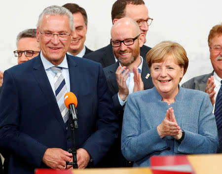 Christian Democratic Union CDU party leader and German Chancellor Angela Merkel and Joachim Herrmann of the Christian Social Union in Bavaria (CSU) react after winning the German general election (Bundestagswahl) in Berlin, Germany, September 24, 2017. REUTERS/Fabrizio Bensch