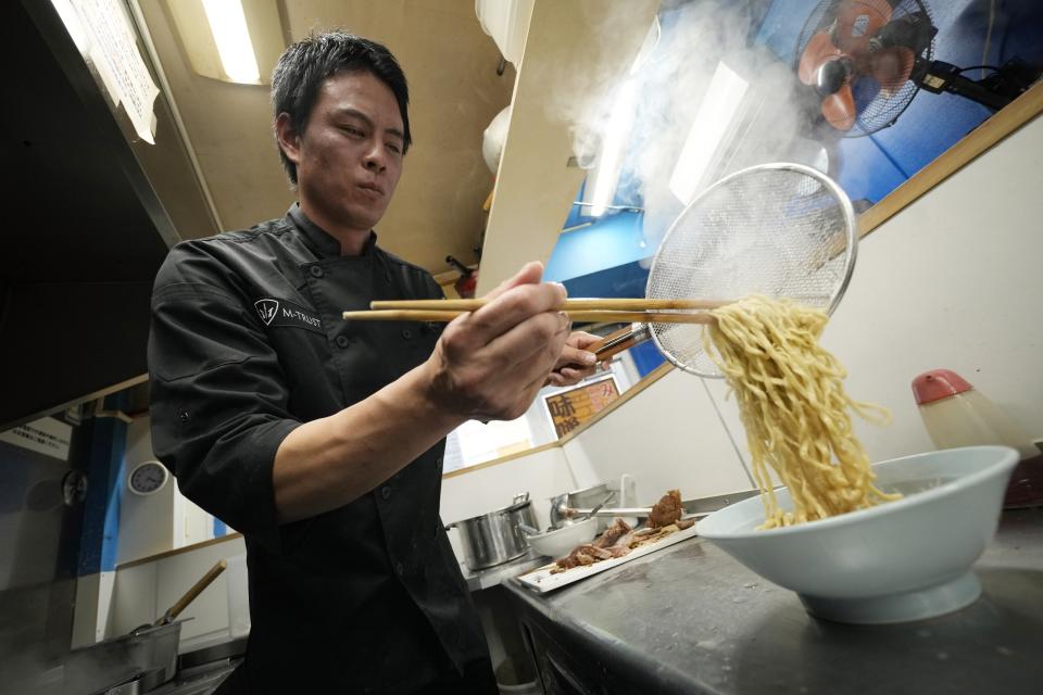 Kota Kobayashi prepares a bowl of noodle at his chain called "Ore No Ikiru Michi" in Tokyo on April 17, 2024. (AP Photo/Eugene Hoshiko)