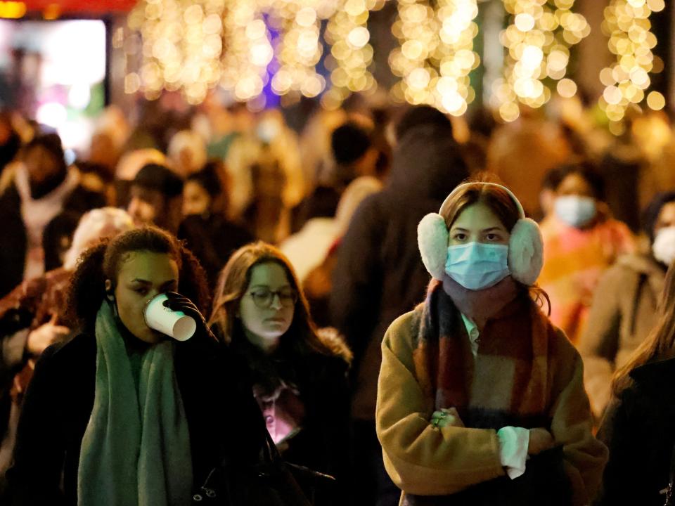 Shoppers walk along Oxford Street, in central London, as face masks return in some public spaces (AFP via Getty Images)