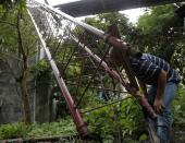 A man checks a fallen television tower in the aftermath of Typhoon Haiyan in Vietnam's northern Quang Ninh province, 112 miles away from Hanoi, November 11, 2013. (REUTERS/Kham)