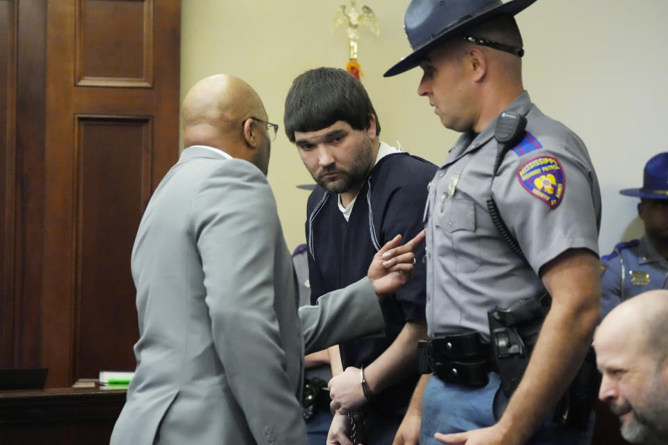 Joshua Hartfield, center, a former City of Richland police officer and one of six former Mississippi law enforcement officers who pleaded guilty to a long list of state and federal charges enters the Rankin County Circuit Court to listen to the victims' impact statements, prior to the state sentencing for his involvement in the 2023 racially motivated torture of two Black men, Wednesday, April 10, 2024, in Brandon, Miss. Time served for the state convictions will run concurrently with the federal sentences, and the men will serve their time in federal penitentiaries. (AP Photo/Rogelio V. Solis)