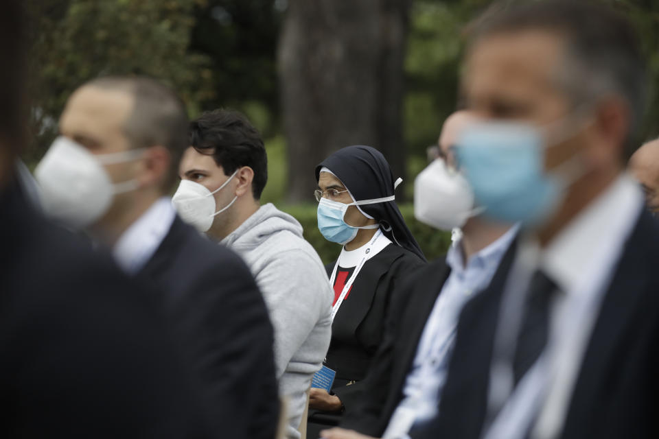 Faithful wearing face mask to prevent the spread of COVID-19 pray during a rosary lead by Pope Francis in Vatican gardens Saturday, May 30, 2020. Pope Francis is reciting a special prayer for the end of the coronavirus pandemic surrounded by a representative sampling of people on the front lines in his biggest post-lockdown gathering to date. (AP Photo/Alessandra Tarantino, pool)