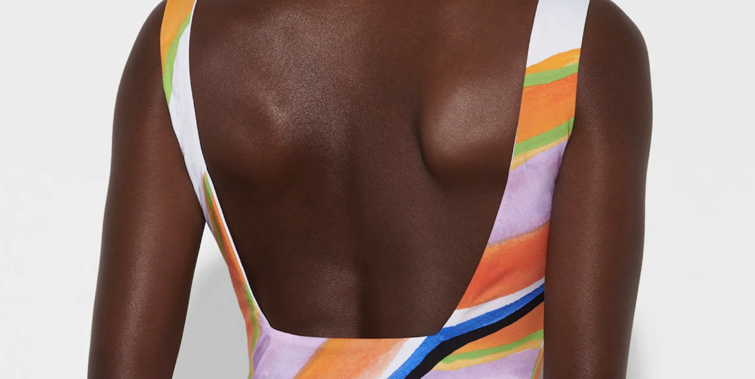 a model wears a watercolor mara hoffman one piece swimsuit in a roundup of the best low back one piece swimsuits of 2023