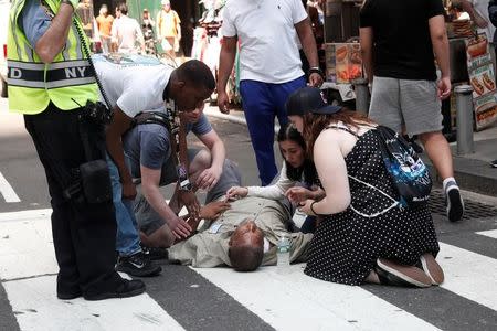 ATTENTION - VISUALS COVERAGE OF SCENES OF INJURY An injured man is seen on the sidewalk in Times Square after a speeding vehicle struck pedestrians on the sidewalk in New York City, U.S., May 18, 2017. REUTERS/Mike Segar