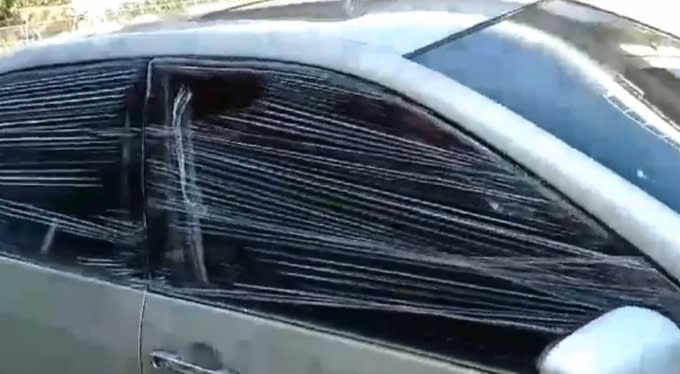 被砸後，車主暫時只能先用保鮮膜把破掉的兩片車窗封起來。（圖／東森新聞）