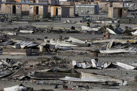 General view shows debris and shelters the day after a fire destroyed large swathes of the Grande-Synthe migrant camp near Dunkirk in northern France April 11, 2017 following skirmishes on Monday that injured several people. REUTERS/Pascal Rossignol