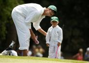 U.S. golfer Bubba Watson's son Caleb holds a pink club as and his mother Angie take part in the par 3 event at Augusta National Golf Course ahead of the 2015 Masters in Augusta, Georgia April 8, 2015. REUTERS/Phil Noble