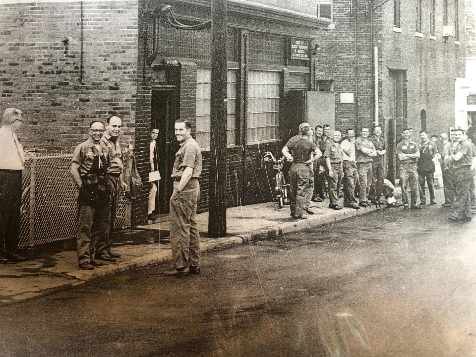 Portsmouth Herald pressmen take a break after a thunderstorm knocked out a transformer, shutting down electricity to the press. Harold Whitehouse Jr., second from left in pressman's apron, stands with the crew on Porter Street, across from The Music Hall.