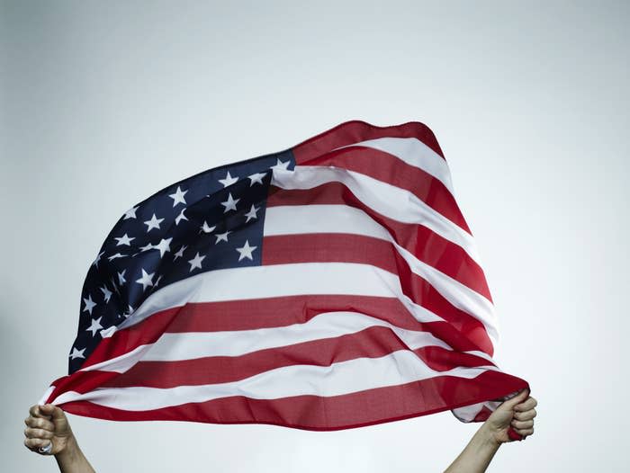 Someone holds an American flag high in the air