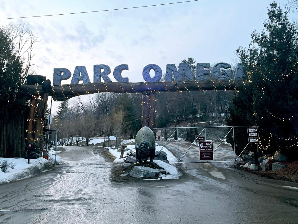 A large wooden archway with big bold letters spelling "Parc Omega" at the entrance of Parc Omega Wolf Cabin