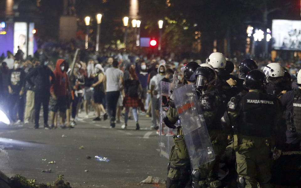 Serbian police officers clash with protesters near the parliament building in Belgrade, Serbia, Tuesday, July 7, 2020. Thousands of people protested the Serbian president's announcement that a lockdown will be reintroduced after the Balkan country reported its highest single-day death toll from the coronavirus Tuesday. (AP Photo/Darko Vojinovic)