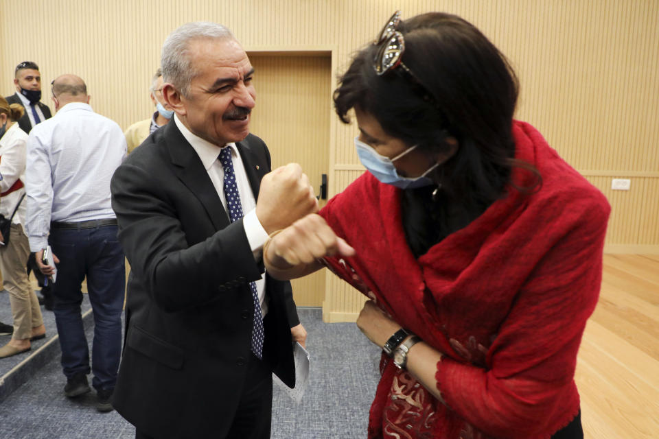 Palestinian Prime Minister Mohammad Shtayyeh, left, greets a journalist with an elbow bump following a press conference at the Foreign Press Association in the West Bank city of Ramallah, on Tuesday, June 9, 2020. The Palestinians said Tuesday they proposed a demilitarized Palestinian state in the West Bank, Gaza and east Jerusalem with one-to-one land exchanges with Israel as a counteroffer to President Donald Trump’s Mideast plan. Shtayyeh declined to provide further details about the 4 1/2-page proposal but said the Palestinian position on major issues is well-known. (Abbas Momani/Pool Photo via AP)