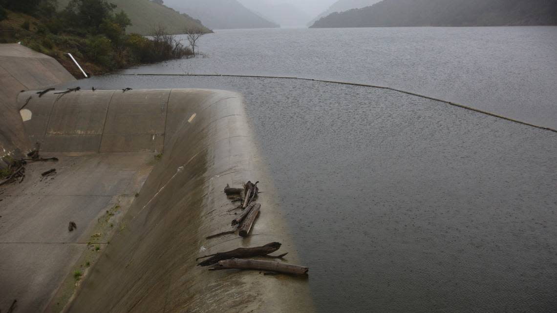 Lopez Lake trickles over its spillway on Feb. 7, 2024, after atmospheric river storms dumped several inches of rain on the reservoir’s watershed.