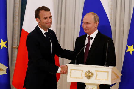 Russian President Vladimir Putin (R) and his French counterpart Emmanuel Macron shake hands as they leave after a news conference in St. Petersburg, Russia May 24, 2018. REUTERS/Grigory Dukor