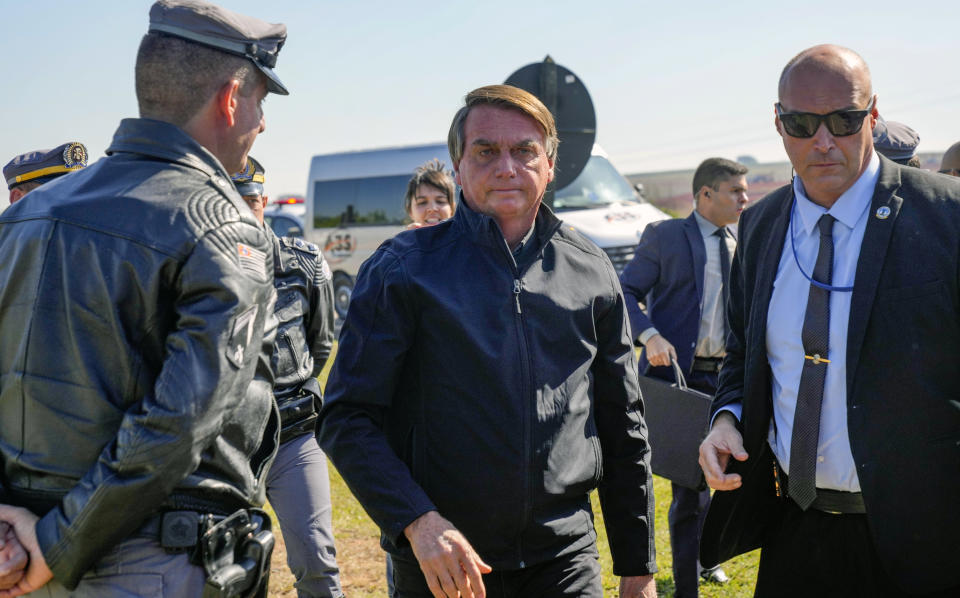 Brazilian President Jair Bolsonaro arrives to a resort hotel where he is expected to meet with Elon Musk in Porto Feliz, Brazil, Friday, May 20, 2022. The Telsa and SpaceX chief executive officer tweeted that he was in Brazil to help bring Internet service to rural schools in the Amazon and to help monitor the Amazon environmentally. (AP Photo/Andre Penner)