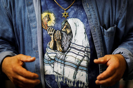 A print of an orthodox Jewish man sounding the Shofar, a ram's horn, is seen on the shirt of Shofar maker Robert Weinger, in his workshop in Rishon Lezion, Israel, February 27, 2018. Picture taken February 27, 2018. REUTERS/Amir Cohen