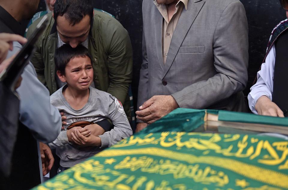 Mustafa, the 10-year-son of Afghan reporter Zabihullah Tamanna, is consoled as friends and relatives gather around his father's coffin in Kabul on June 7, 2016. Tamanna, a 38-year-old father of three, was killed alongside National Public Radio photojournalist David Gilkey in&nbsp;a Taliban ambush two days earlier.