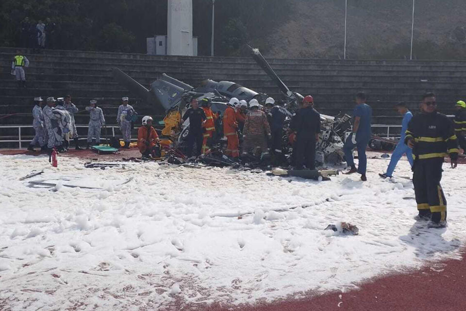 CORRECTS THE SOURCE - In this photo released by Fire & Rescue Department of Malaysia, fire and rescue department inspect the crash site of two helicopter in Lumur, Perak state, Monday, April 23, 2024. Malaysia's navy says two military helicopters collided and crashed during a training session, killing all 10 people on board. (Fire & Rescue Department of Malaysia via AP)