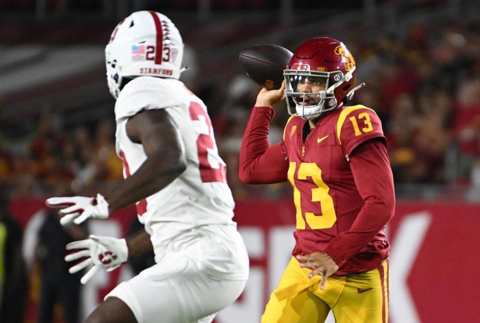 USC quarterback Caleb Williams evades a Stanford player to pass the ball.