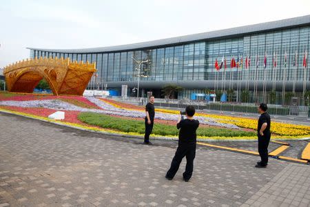 People take pictures in front of the China National Convention Center, a venue of the upcoming Belt and Road Forum in Beijing, China, May 12, 2017. REUTERS/Thomas Peter