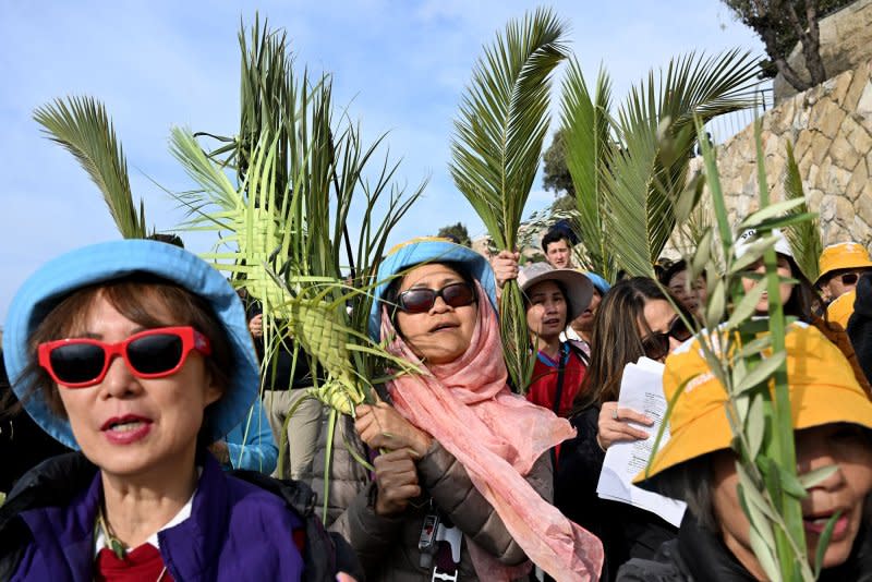 Christians wave olive and palm branches during the traditional Palm Sunday procession on the Mt. Of Olives, overlooking the Old City of Jerusalem, East Jerusalem, on Sunday, March 24, 2024. Photo by Debbie Hill/ UPI