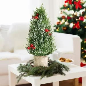 bobora tabletop christmas tree with ornaments sitting on a white table top