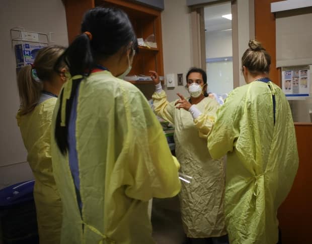 Nurses prepare before attending to a COVID-19 patient in an ICU unit. (Submitted by AHS/Leah Hennel - image credit)