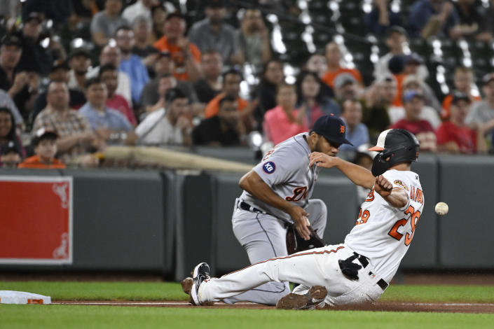 Baltimore Orioles' Ramon Urias advances to third base on a single by Cedric Mullins, avoiding the tag from third baseman Jeimer Candelario during the third inning of a baseball game Wednesday, Sept. 21, 2022, in Baltimore. (AP Photo/Terrance Williams)