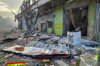 FILE - Debris lies on the street outside damaged shops in Chinatown during two days of riots, sparked by underlying grievances, including concerns of the country's increasing links with China, Honiara, Solomon Islands on Nov. 26, 2021. China’s Foreign Minister Wang Yi is visiting the South Pacific with a 20-person delegation this week in a display of Beijing's growing military and diplomatic presence in the region. (AP Photo/Piringi Charley, File)