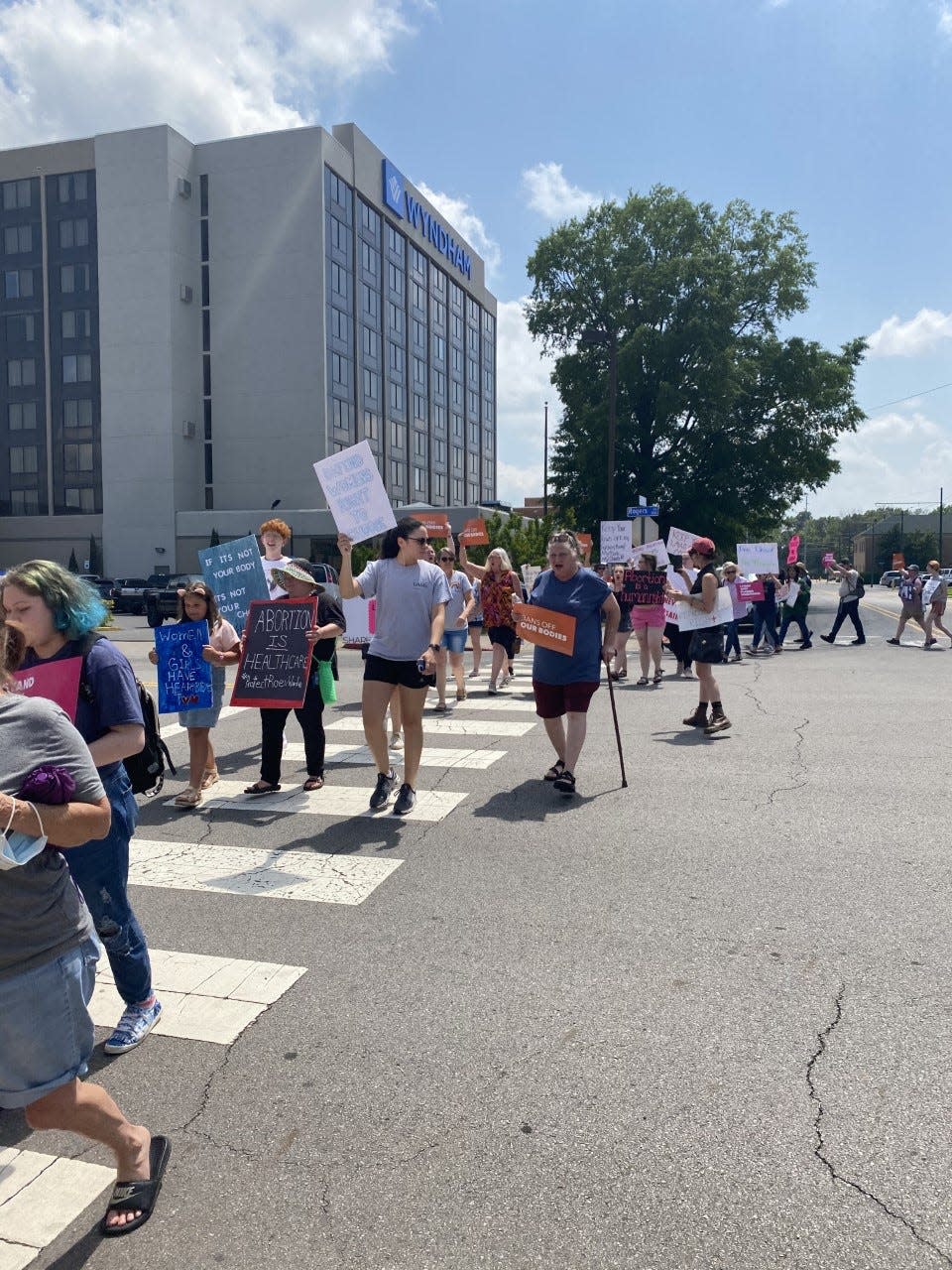 People walk to Garrison Avenue, chanting "ho ho hey hey women’s rights are here to stay."