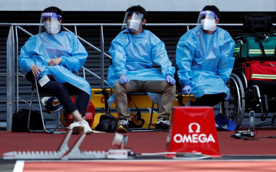 Medical officers wearing PPE at the Olympic Stadium in Tokyo - Reuters