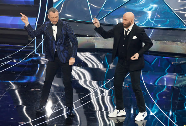 SANREMO (IMPERIA) ITALY – FEBRUARY 07 2024; Sanremo Festival host and artistic director Amadeus with US actor John Travolta on stage at the Ariston Theatre during the 74th Sanremo Italian Song Festival. (Photo credit should read Marco Ravagli/Future Publishing via Getty Images)