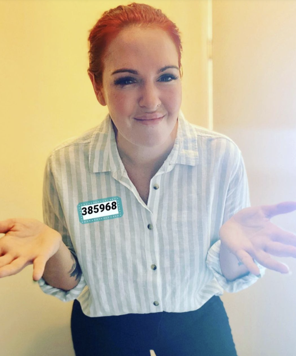 Sarah Mills wearing a striped shirt with a six-digit number on a sticker on her chest. 