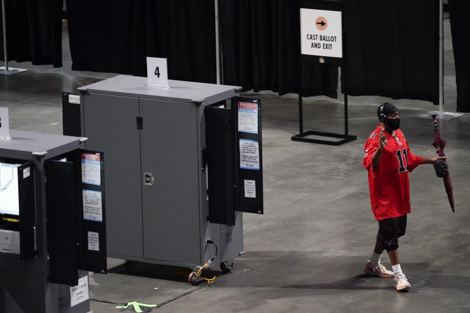 A man tries to vote but walks away after the machine stopped working during early voting at the State Farm Arena on Monday, Oct. 12, 2020, in Atlanta. (AP Photo/Brynn Anderson)