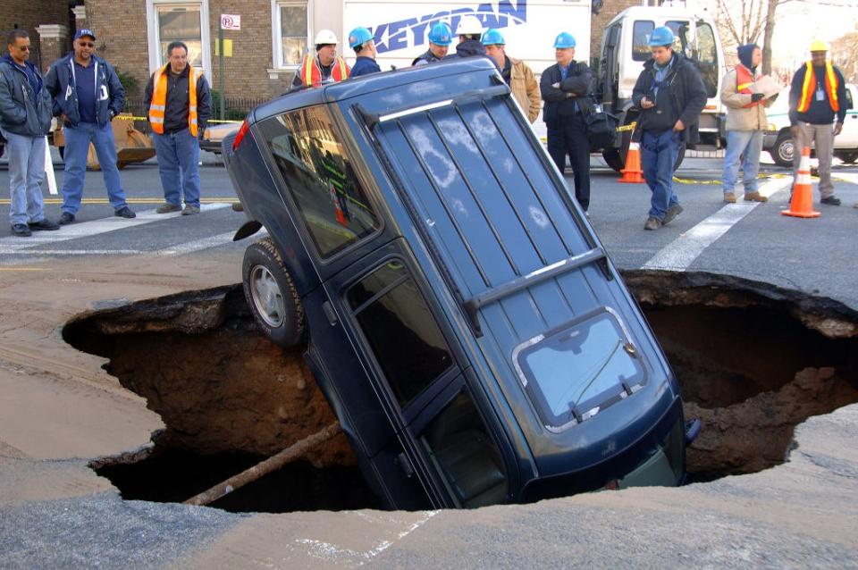 A sinkhole in the Bay Ridge section of Brooklyn swallows up a Ford SUV.