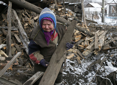A woman reacts as she removes debris in front of her house, which was damaged during fighting between pro-Russian rebels and Ukrainian government forces, in the town of Horlivka, eastern Ukraine February 10, 2015. REUTERS/Maxim Shemetov