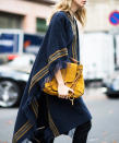 <p>The modern bohemian wears a fringed poncho and carries her mustard yellow <a rel="nofollow noopener" href="https://www.chloe.com/us/shoulder-bag_cod45325001jh.html" target="_blank" data-ylk="slk:Chloe;elm:context_link;itc:0;sec:content-canvas" class="link "> Chloe </a> shoulder bag like a clutch.</p>