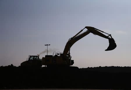 An excavator loads a lorry with earth from the Crossrail project which will be used to landscape a saltwater marsh wildlife habitat on Wallasea island, in Essex, March 13, 2014. REUTERS/Andrew Winning